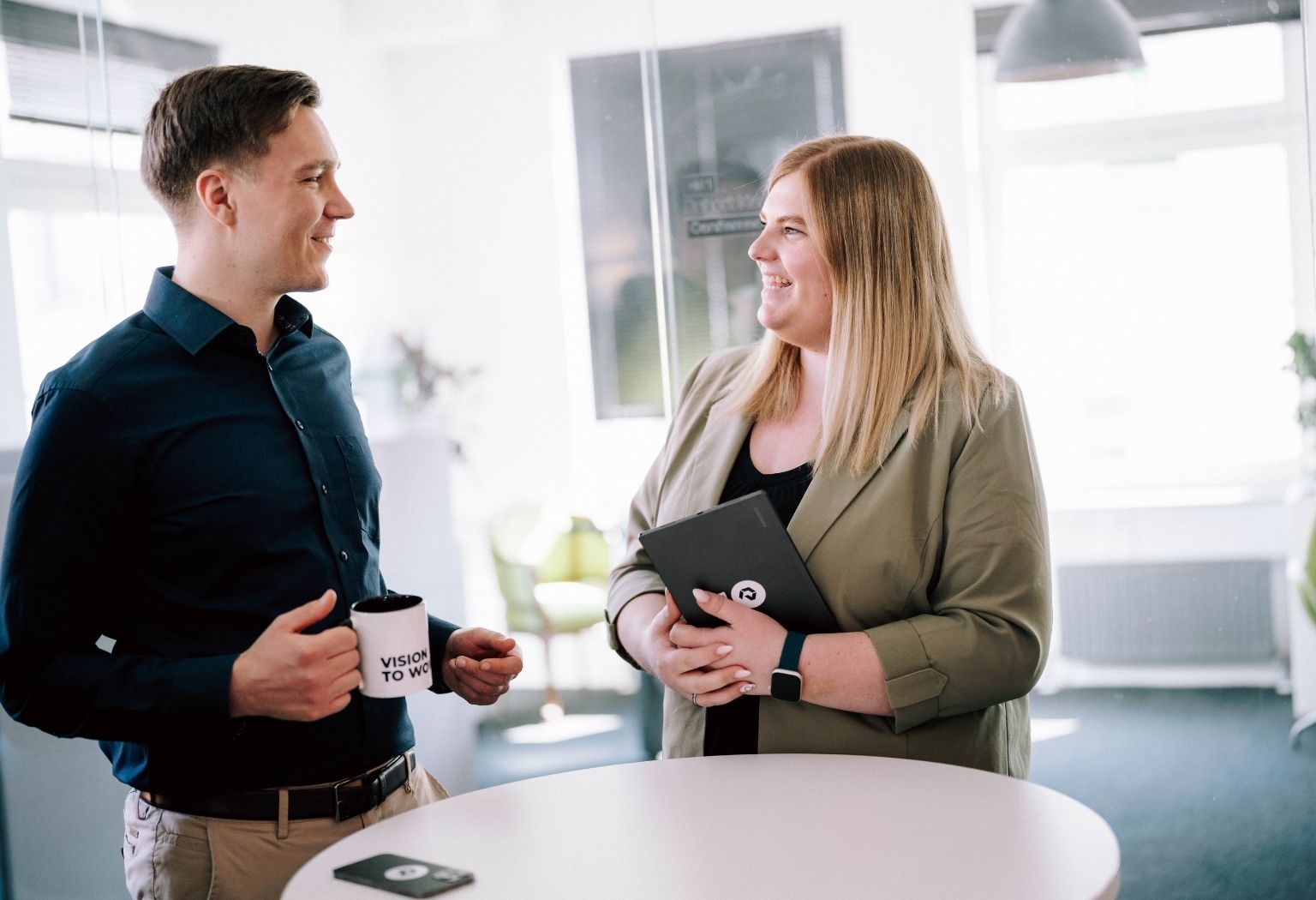 Ein Mann und eine Frau führen ein Gespräch in einem modernen Büro.
